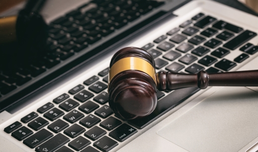 A wooden gavel rests on a laptop keyboard